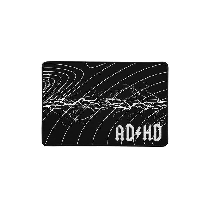 Black AD/HD High Voltage desk mat featuring an electric lightning pattern and gold logo, designed for gaming, coding, and high-energy workspaces.