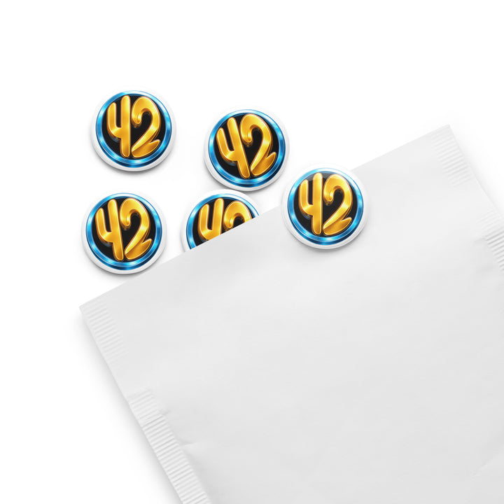 Set of five 42 Circle 1.25" pin buttons featuring a gold “42” inside a blue ring on a black background, displayed partially inside a white envelope sleeve with glossy finish.
