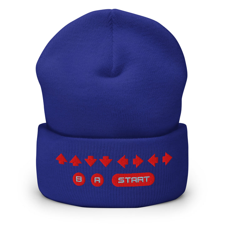 Front view of a blue cuffed beanie featuring embroidered retro cheat code arrows and classic B, A, START symbols on the cuff.