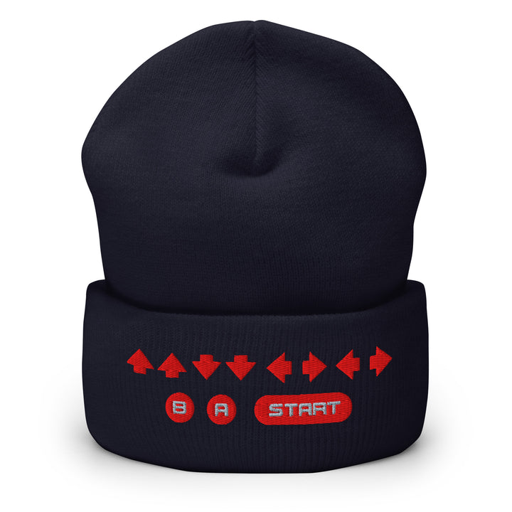 Front view of a navy cuffed beanie with embroidered retro cheat code arrow sequence and B, A, START symbols across the cuff.