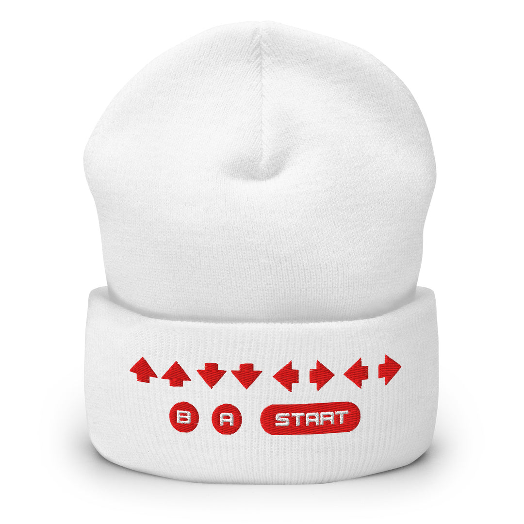 Front view of a white cuffed beanie featuring embroidered retro cheat code arrows and B, A, START icons across the folded cuff.