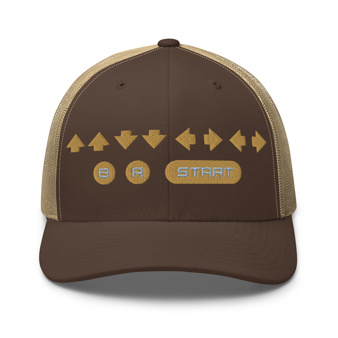 Front view of a brown and khaki snapback trucker cap with gold embroidered retro cheat code arrows and B A START buttons on the front panel