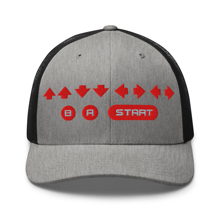 Front view of a heather gray and black snapback trucker cap with red embroidered retro cheat code arrows and B A START buttons on the front panel