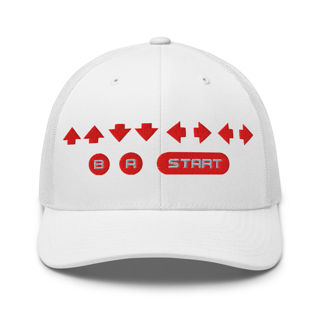 Front view of a white snapback trucker cap with red embroidered retro cheat code arrows and B A START buttons on the front panel