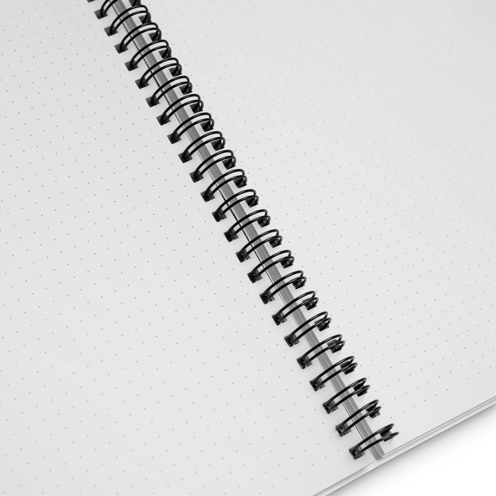 Interior view of a spiral notebook showing white dotted pages with black wire-o binding.