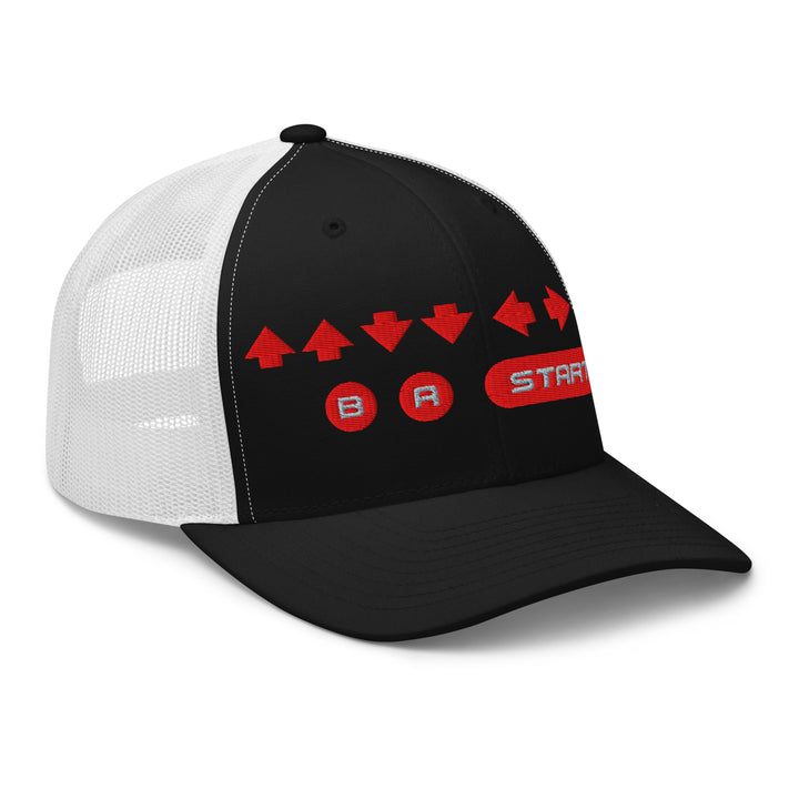 Front right view of a model wearing a retro gaming trucker cap with embroidered directional arrows and B A Start button symbols