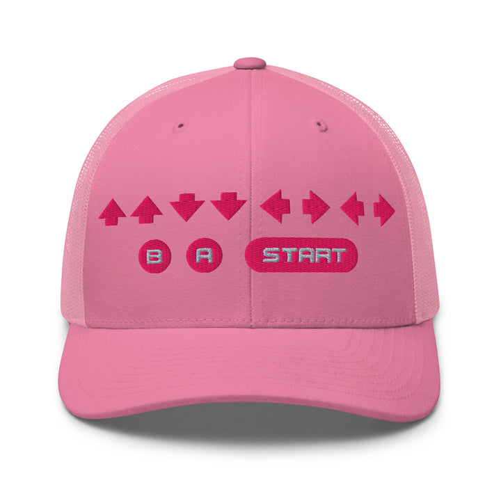Pink trucker cap with pink embroidered retro cheat code arrows and B A Start buttons, playful girl gamer–inspired design