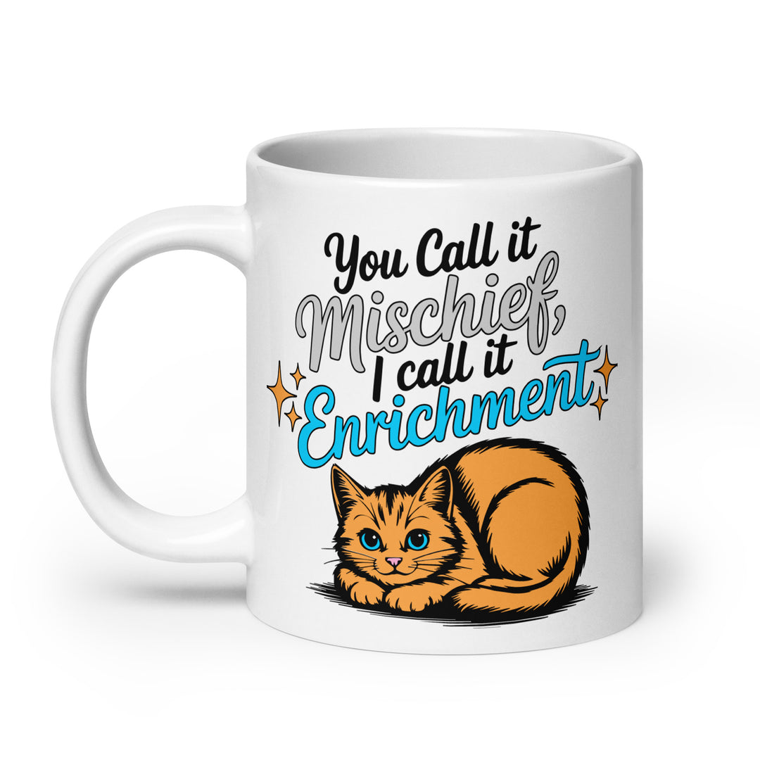 Right side view of the Keep It Geek “You Call It Mischief, I Call It Enrichment” orange cat glossy coffee mug, featuring bold typography with logo-matched blue accents and an illustrated orange cat resting beneath the phrase on a white ceramic mug.