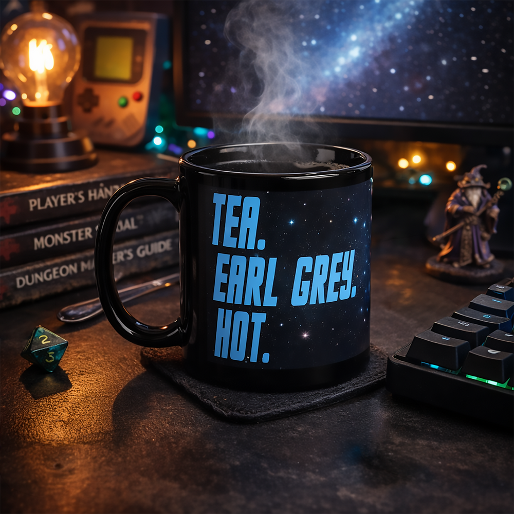 Black glossy “Tea. Earl Grey. Hot.” mug on a moody geek desk setup with polyhedral die, keyboard lighting, and a starfield screen—ready for a captain-level tea break.