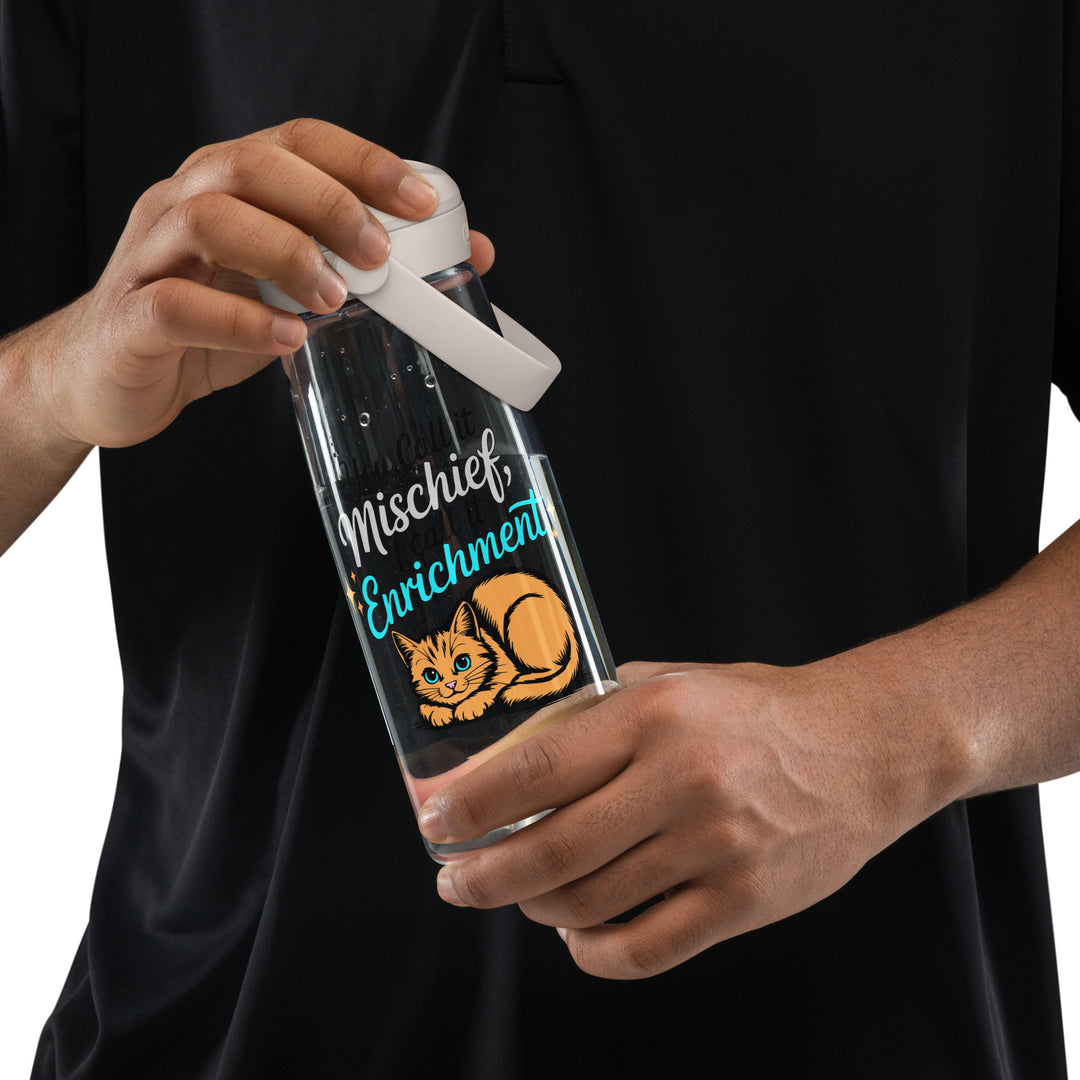 Person holding a clear Camelbak flip-straw water bottle with “You Call it Mischief, I Call it Enrichment” orange cat design.